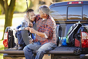 Father And Son Sitting In Pick Up Truck On Camping Holiday