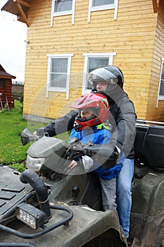 Father with son sitting on quad bike