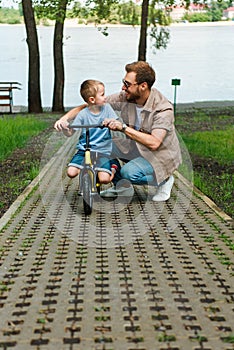 father and son with small bike looking at each other