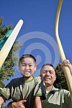 Father and Son Smiling on Jungle Gym - Vertical