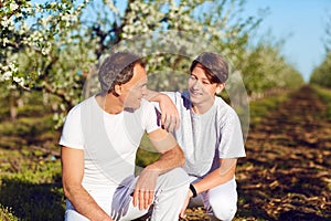 Father and son are smiling in nature.