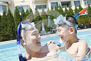 Father and son with snorkeling equipment in the pool