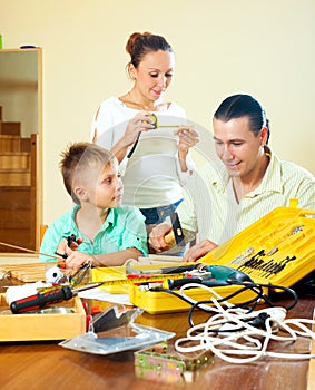 Father and son spend their free time with working tools at home