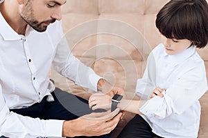 Father and son spend time together. Dad and son in the same clothes. Dad helps his son.