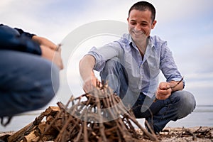 Father and son spending happy leisure time together outdoors in the camp. Family man child making campfire on nature