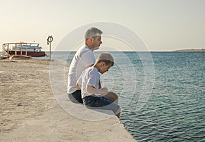 Father and  son  spending time together sea vacation. Young man, little boy walking beach Fathers day. Family with one child.