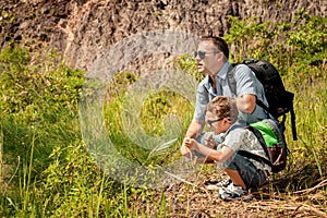 Father and son standing near the pond at the day time.