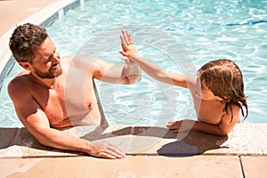 Father and son swimming in pool, summer family. Child with dad playing in swimmingpool. Family time. Summer vacation