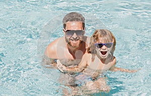 Father and son swimming in pool, summer family. Happy family in pool at summer weekend. Swimming lessons. Father son