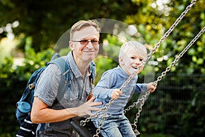 Father and son are swinging