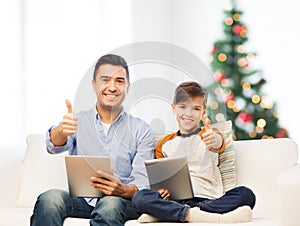 Father and son with tablet pc showing thumbs up