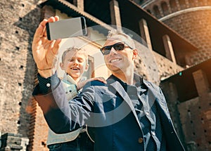 Father with son take a selfie photo in old castle