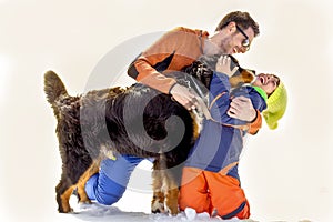 Father, son and their dog having fun in the snow