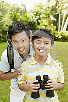 Father and son together, boy holding binoculars. Conceptual image