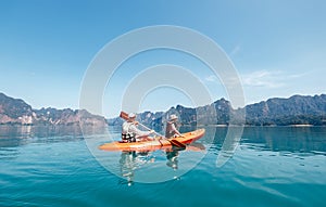 Father and son together paddling in kayak on the Cheow Lan lake in Thailand. Vacation with kids concept image