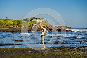 Father and son tourists on the background of Tanah Lot - Temple