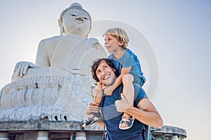 Father and son tourists on the Big Buddha statue. Was built on a