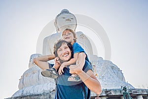 Father and son tourists on the Big Buddha statue. Was built on a
