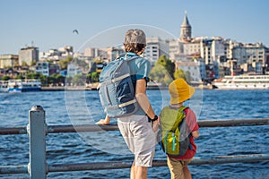 Father and son tourists enjoy Istanbul city skyline in Turkey, Beyoglu district old houses with Galata tower on top