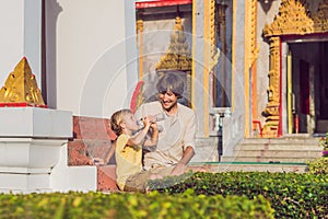 Father and son tourists look at Wat Chalong is the most important temple of Phuket