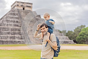 Father and son tourists observing the old pyramid and temple of the castle of the Mayan architecture known as Chichen