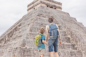 Father and son tourists observing the old pyramid and temple of the castle of the Mayan architecture known as Chichen