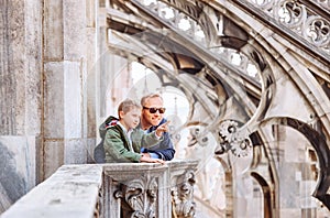 Father with son tourists are on the roof of Milan Cathedral