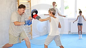 Father and son training boxing in studio