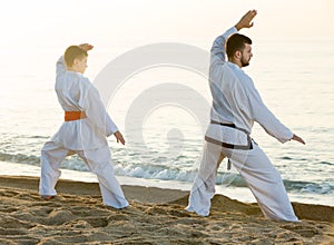 Father and son in uniform doing exercises