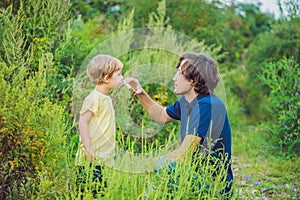 Father and son use a spray from an allergy because of an allergy to ragweed