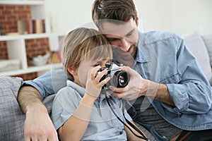 Father and son using a camera