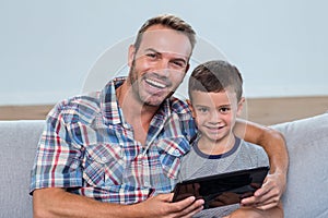 Father and son using digital tablet