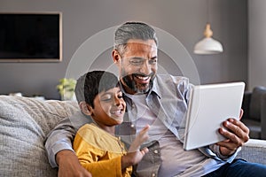 Father and son using digital tablet to make a video call