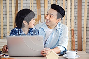 Father and son using laptop computer.