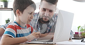 Father with son using laptop at home