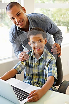 Father And Son Using Laptop At Home