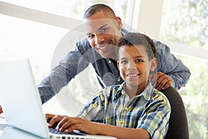 Father And Son Using Laptop At Home