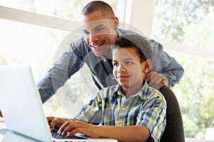 Father And Son Using Laptop At Home