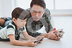 Father son in using the smartphone together for modern family and parenting concept