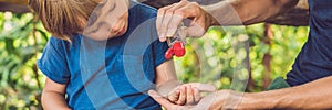 Father and son using wash hand sanitizer gel in the park before a snack BANNER, long format