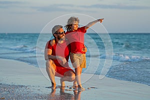 Father and son walk in sea beach. Concept of friendly family. Happy family on beach, summer holiday vacation. Dad with