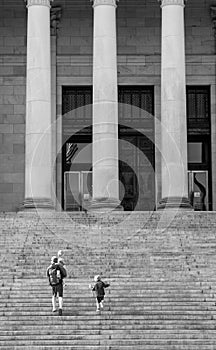 Black and white image of people walking up the steps of the Washington State Capitol building