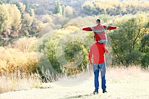 father and son walking in the park in autumn