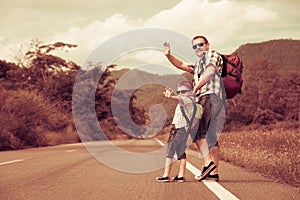 Father and son walking on the road at the day time