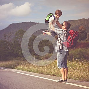 Father and son walking on the road at the day time