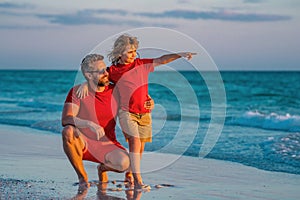 Father and son walking together on the beach. Fatherhood family concept. Travel on sea with father. Relax on beach