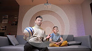 father and son watching a football match at home together