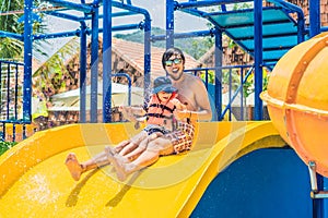 Father and son on a water slide in the water park