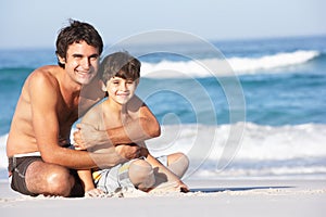 Father And Son Wearing Swimwear Sitting Down