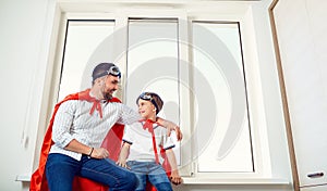 Father and son at the window in the room.